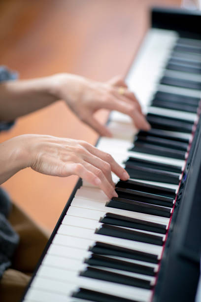 istock Woman playing piano at home 953679464