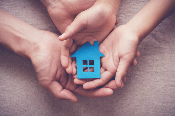 Adult and child hands holding paper house, family home and homeless shelter concept Adult and child hands holding paper house, family home and homeless shelter concept housing difficulties stock pictures, royalty-free photos & images