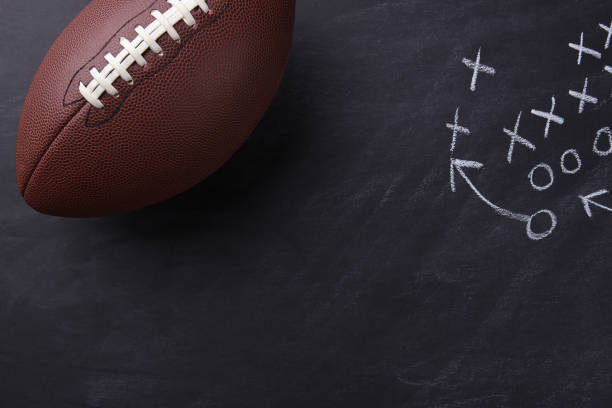 American Football on Chalkboard Top view of an American style football on a chalkboard with a play diagramed. Horizontal format with copy space. pigskin stock pictures, royalty-free photos & images