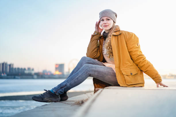 istock Young woman sitting alone next to river 953690836