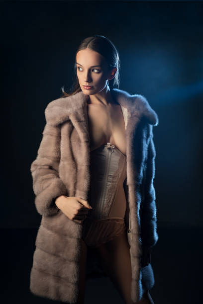 istock Pretty brunette topless in fur coat in the dark 953704072