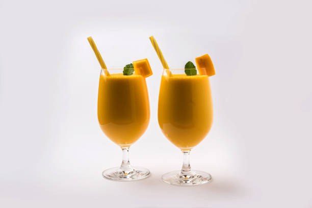 Mango Lassi or smoothie in big glass with mint leaf. Side angle  Isolated over colourful background. Selective focus