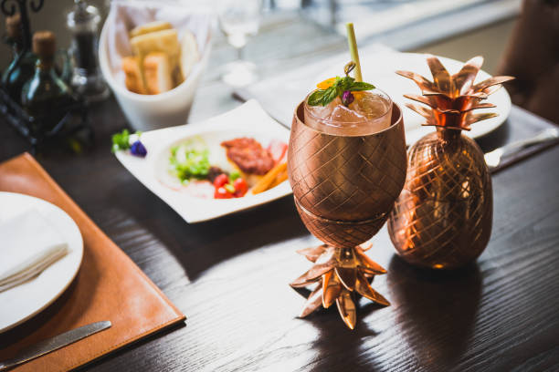 istock Cocktail served inside copper pineapple cup with dishes in the background. 953704954