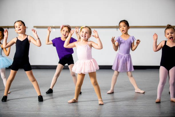 Lined Up Diverse Young Students in Dance Class A diverse young group of students practice in musical theatre and ballet combo dance class ballet stock pictures, royalty-free photos & images