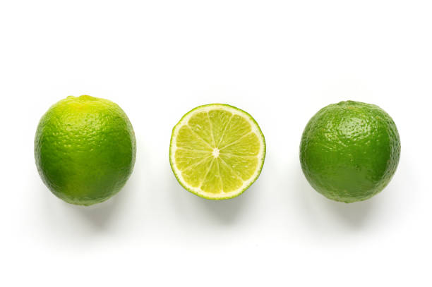 cales de aislados. - limones verdes fotografías e imágenes de stock