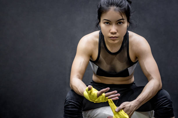 asiatique boxer femelle porte jaune bracelet poignet - ready to fight photos et images de collection