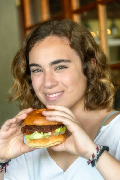 istock Smiling young woman having a hamburger 953718452