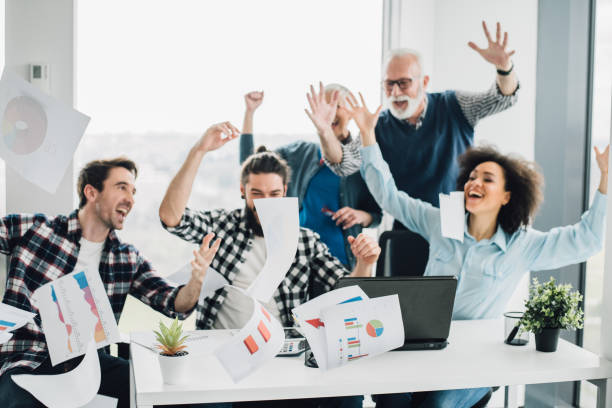 istock Ecstatic coworkers of all ages throwing paper at work 953727734