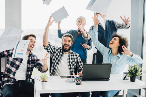 istock Happy coworkers throwing documents in air 953727746