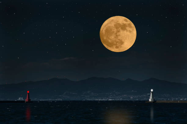 istock Full moon rising over the sea and the lighthouse 953728778
