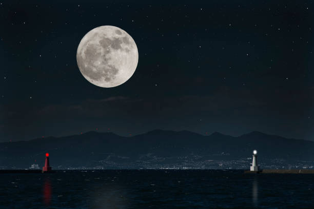Full moon rising over the sea and the lighthouse