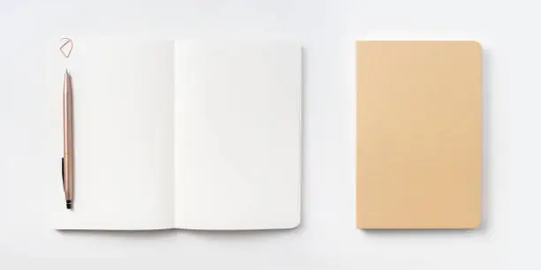 Photo of Top view of hardcover kraft notebook and ballpoint pen