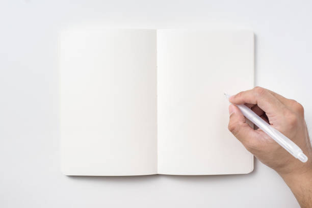 istock Top view of notebook blank page and man's hand holding ballpoint pen 953732796
