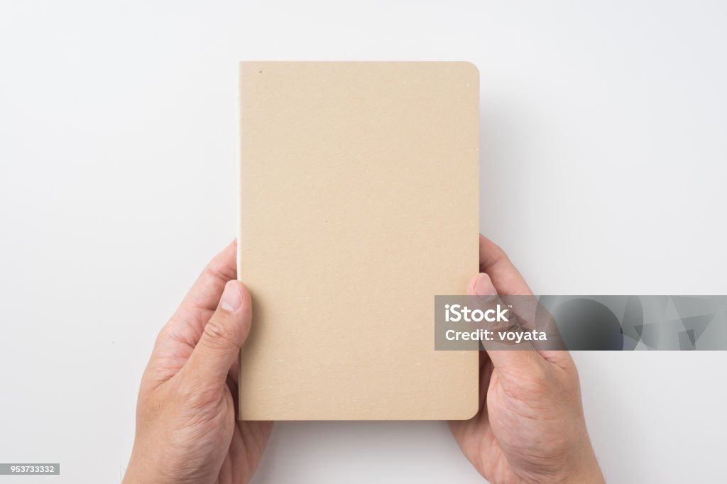 Vista superior de la mano del hombre cuaderno tapa dura kraft - Foto de stock de Cuaderno de apuntes libre de derechos
