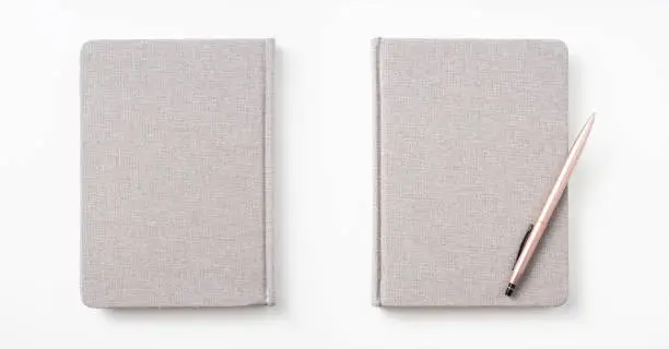 Photo of Top view of hardcover gray linen notebook and ballpoint pen