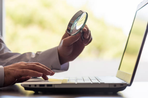 istock Searching On Internet Concept, Business Metaphore with Man Holding Magnifying Glass Over Computer 953738766