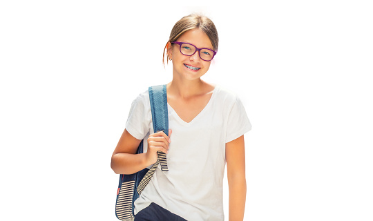 Portrait of modern happy teen school girl with bag backpack. Girl with dental braces and glasses isolated on white.