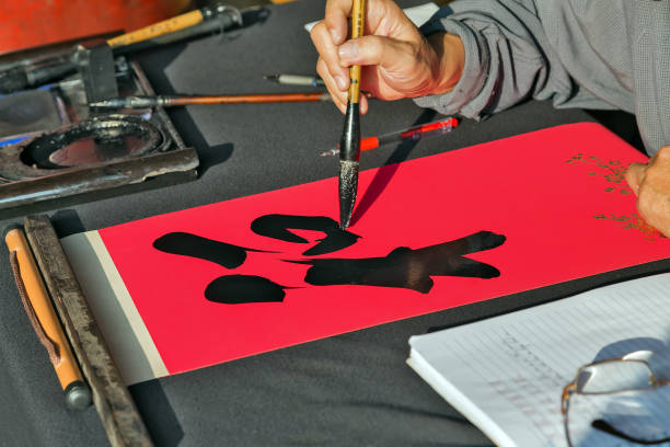 istock Calligrapher hands writing chinese hieroglyph. 953747562
