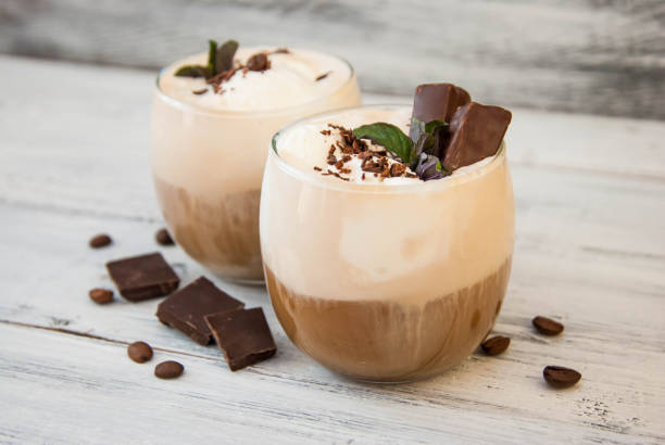 Iced Mocha Coffee with Whip Cream, Summer Drinking times. Coffee Beans. rustic textured Wooden Background. Mint Leaves Iced Mocha Coffee with Whip Cream, Summer Drinking times. Coffee Beans. rustic textured Wooden Background. mocha stock pictures, royalty-free photos & images
