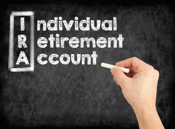 istock IRA - Individual Retirement Account concept. Hand writing by white chalk on a blackboard. 953757718