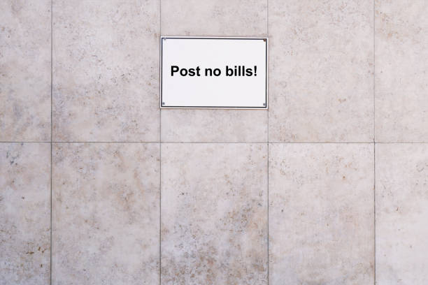 prohibition sign reads post no bills, marble textured stone wall background with copy space