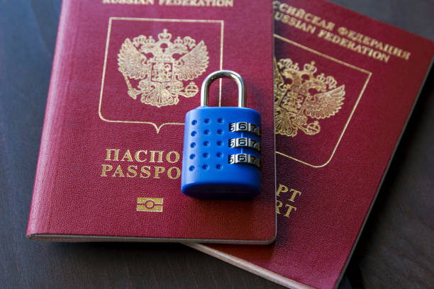 istock Blue lock lying on two red passports on a wooden background, close-up 953773464