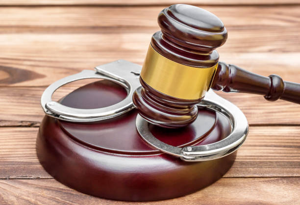 istock Judge's gavel with stand and handcuffs on wooden table. 953778964
