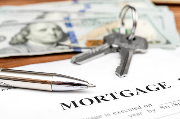 istock Mortgage form with pen, money and keys on the table. 953779136