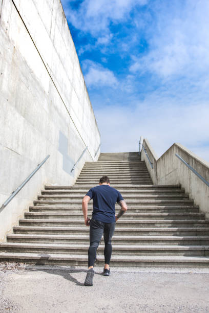 istock Man preparing for a run in front of a staricase 953793596