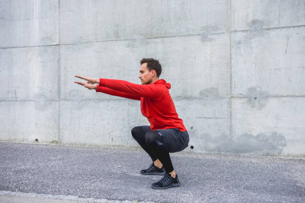 istock Man crouching and exercising outdoors 953793602