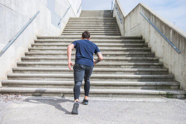 istock Man preparing for a run in front of a staricase 953793654