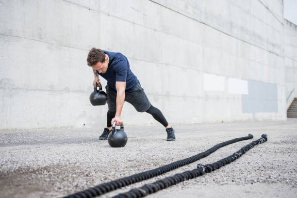 istock Athlete exercising with kettlebells outdoors 953793688