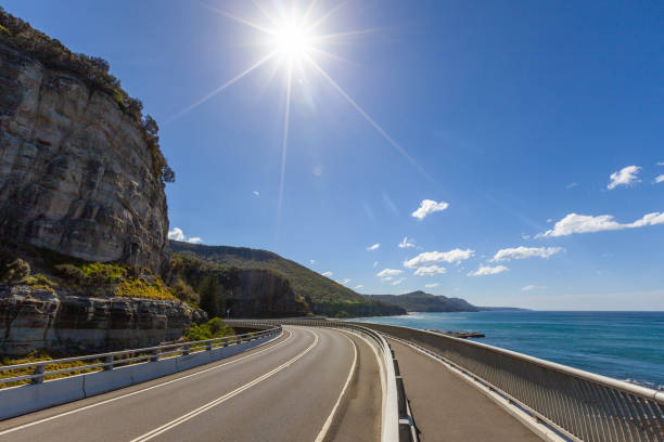 luz do sol brilhando na sea cliff bridge, em sydney, austrália - pacific coast highway - fotografias e filmes do acervo