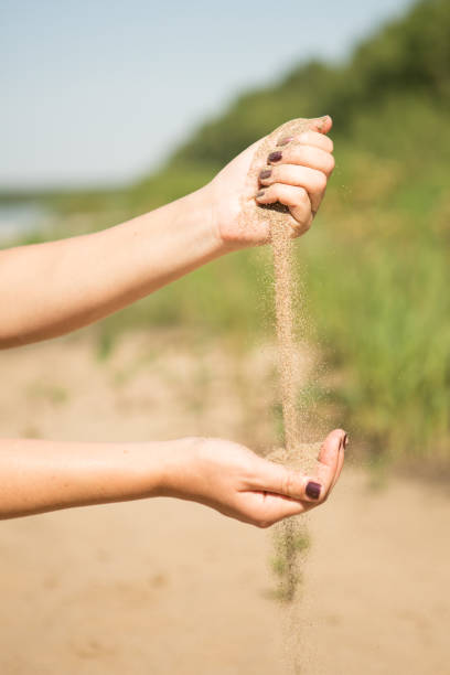 istock sand running through hands of woman 953799952
