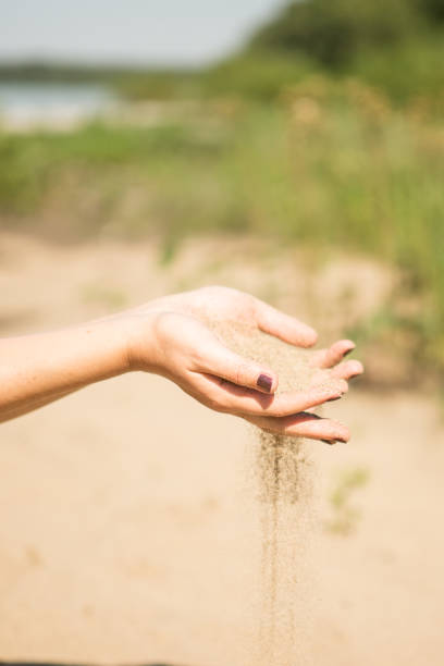 istock sand running through hands of woman 953799982