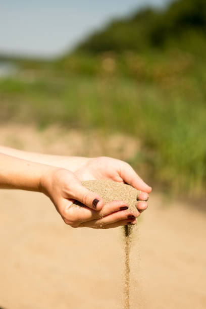 istock sand running through hands of woman 953800190