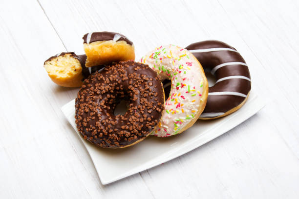 istock Tasty donuts with icing and chocolate on white wooden background, copy space 953800984