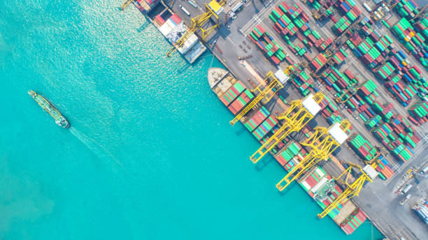 istock Container ship in export and import business and logistics. Shipping cargo to harbor by crane. Water transport International. Aerial view and top view. 953809500