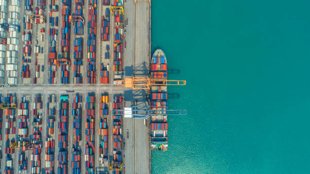 istock Container ship in export and import business and logistics. Shipping cargo to harbor by crane. Water transport International. Aerial view and top view. 953809570