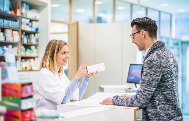 istock Female pharmacist serving a male customer. 953810230