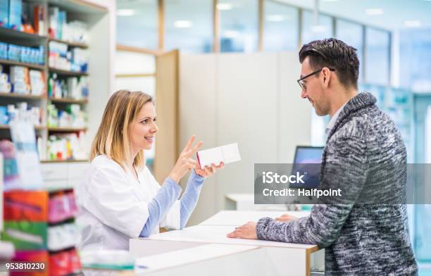 Female Pharmacist Serving A Male Customer Stock Photo - Download Image Now - Pharmacy, Advice, Pharmacist