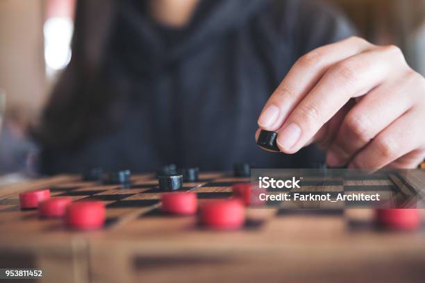Closeup Image Of People Playing And Moving Checkers In A Chessboard Stock Photo - Download Image Now