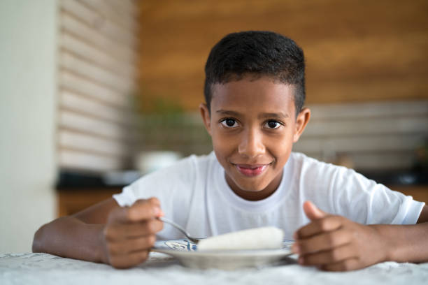 Portrait of a young boy smiling widely while looking towards the camera.