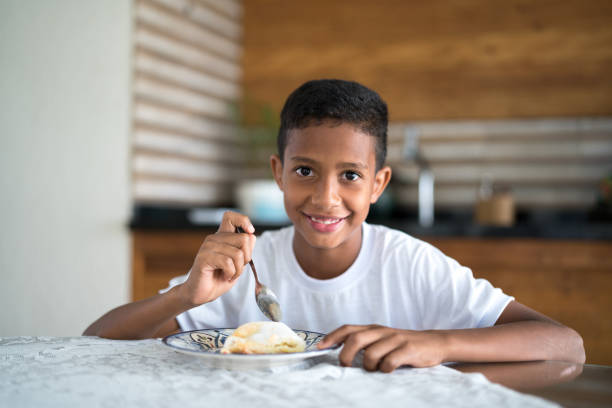 istock Cute brazilian boy eating tapioca as the breakfast 953815394