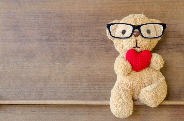 istock Teddy bear holding a heart-shaped pillow 953816284