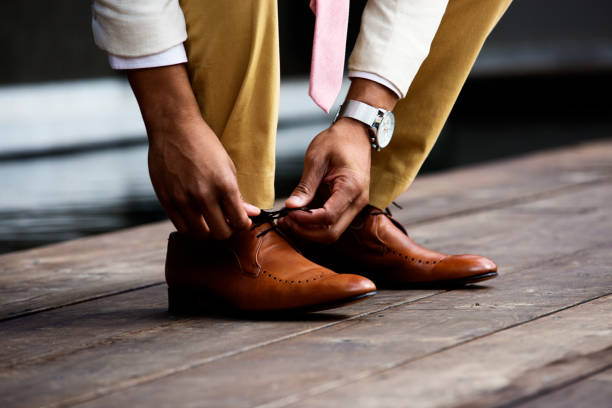 Well dressed man tying his shoe lace