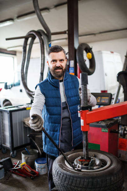 istock Man mechanic repairing a car in a garage. 953819476