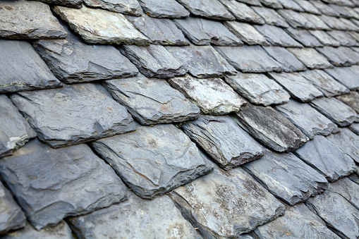 Aged weathered grey slate tile roof in Scotland UK
