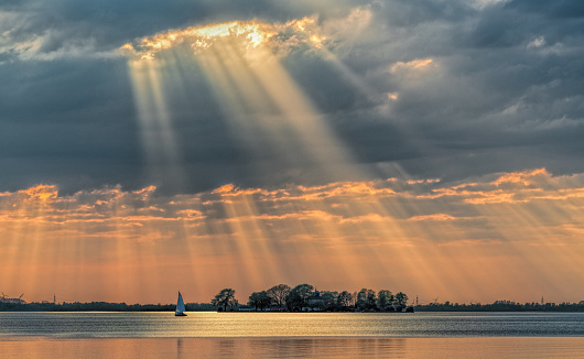 Sunbeams through cloudscape on lake. Location: Lake Steinhuder Meer, Lower Saxony, Germany.