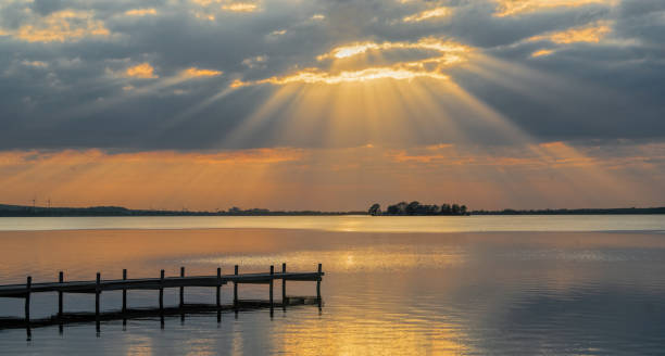 rayons du soleil par le biais de cloudscape sur le lac. - steinhuder meer photos et images de collection